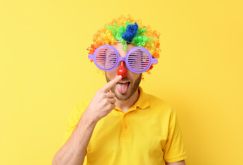 Fototapeta premium Funny young man in disguise on yellow background. April fools' day celebration