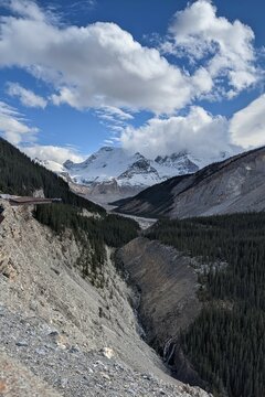 Sunwapta Valley, Alberta, Canada on a cloudy day. The river carves a path towards the snow covered mountains, creating a valley with twists and turns.