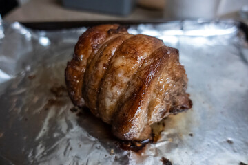 Close up, selective focus on a juicy, pork chashu roast resting on tin foil after being cooked