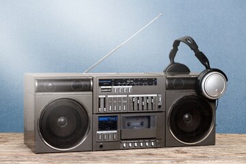 Retro boombox outdated portable black radio receiver with a cassette recorder on the desk