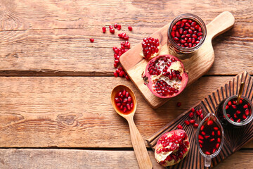 Jars and gravy-boat of pomegranate molasses on wooden background