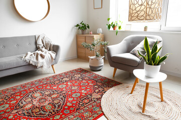 Interior of cozy living room with armchair, houseplants and vintage carpet