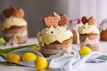 Delicious Easter cakes decorated with cookies and painted eggs on table in room, closeup