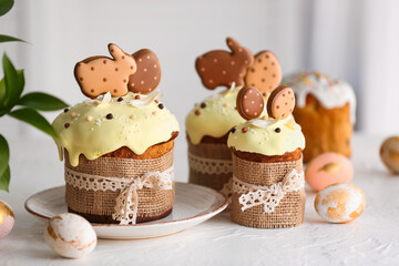 Delicious Easter cakes decorated with cookies and painted eggs on table in room
