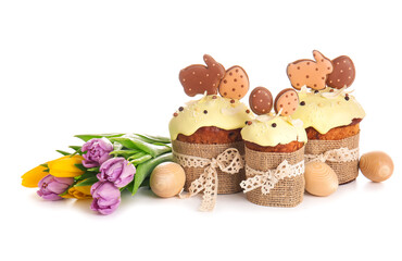 Delicious Easter cakes decorated with cookies, wooden eggs and flowers on white background