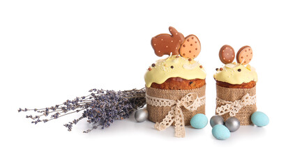 Delicious Easter cakes decorated with cookies, lavender and painted eggs on white background