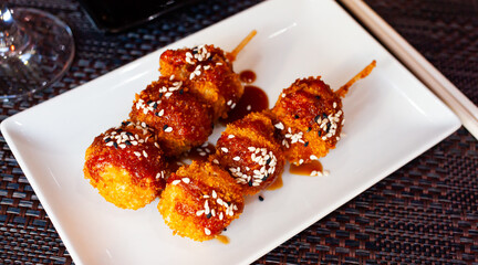 Delicious Japanese fried chicken balls on skewers with teriyaki sauce. Traditional Japanese food