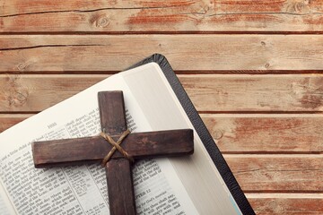 Religious wooden cross on the pages of a bible