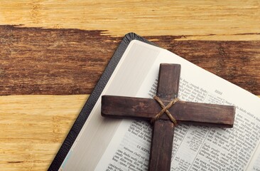 Religious wooden cross on the pages of a bible