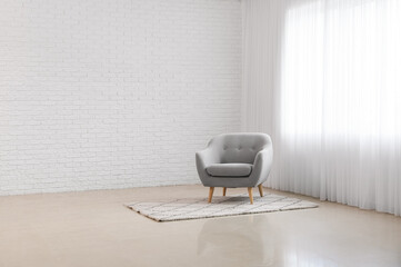 Modern armchair and carpet in big light room