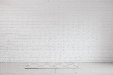 View of white brick wall and carpet in big room