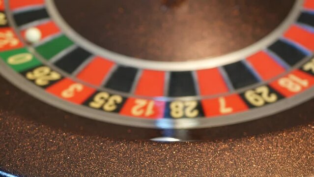 Ball on wooden french roulette table in casino. Wheel spinning, turning or rotating. Odd and even numbers, black, red and zero sectors. Bets in game of chance. Money playing, gambling or risky betting