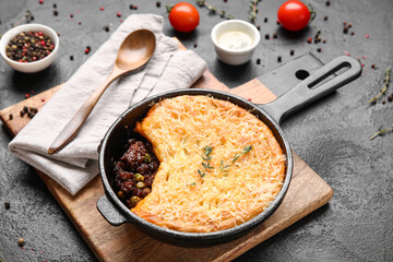 Frying pan with tasty Shepherd's pie on black background