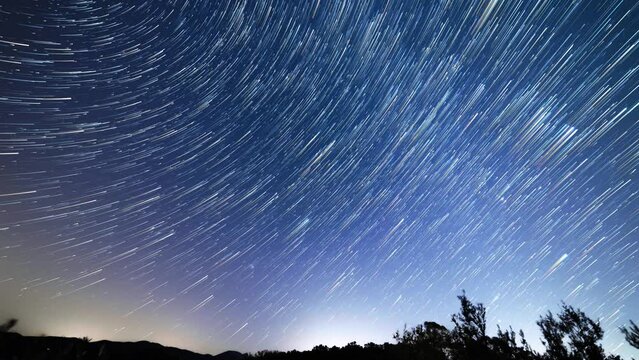 Time lapse of star trails, night sky in the Tuscan country, Italy. 4K. Backlight landscape with stars movement