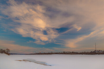 the setting sun beautifully illuminates the clouds over the city on a frosty winter evening
