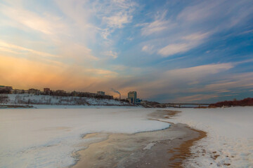 the setting sun beautifully illuminates the clouds over the city on a frosty winter evening