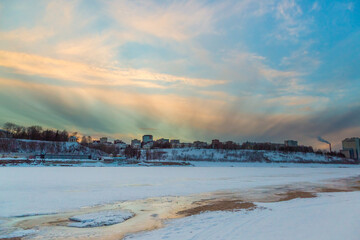 the setting sun beautifully illuminates the clouds over the city on a frosty winter evening