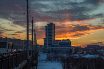 the setting sun beautifully illuminates the clouds over the city on a frosty winter evening
