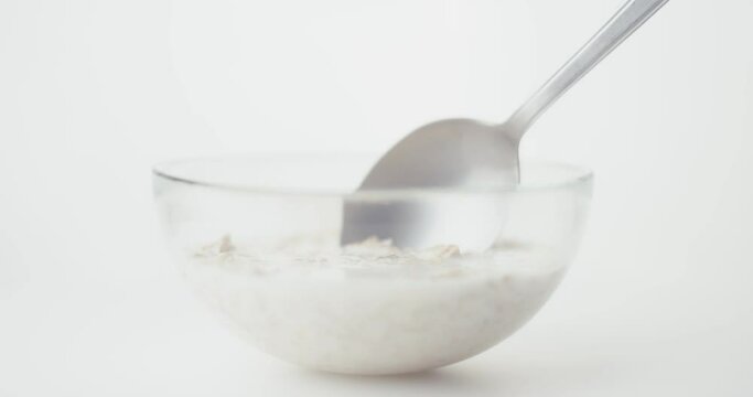 Healthy breakfast oats and milk or oatmeal cup on a spoon in close up