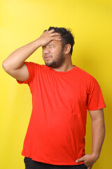 Upset unhappy young fat man in red t-shirt squeezing head with hands, suffering from headache. People, stress, tension and migraine concept