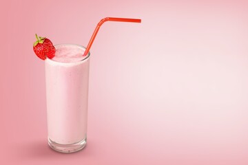 Glass of strawberry yogurt on color pastel  background