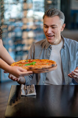 A man eating pizza and looking excited