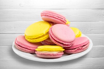 Plate with tasty macaroons on background. Sweet food concept