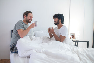 Obraz na płótnie Canvas Gay couple drinking coffee in the morning