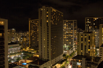 Fototapeta na wymiar The high rise hotels and resorts loom over the Waikiki Beach neighborhood of Honolulu