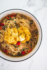 vegan vermicelli noodle soup with roasted cauliflower and bell peppers, healthy plant-based food