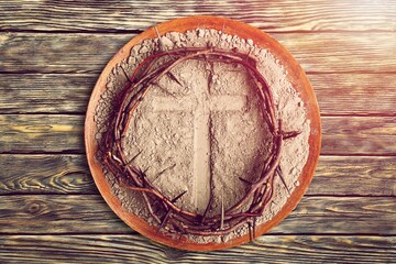 Christian cross with wooden wreath of jesus on plate