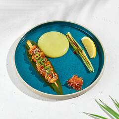 Squid yakitori in ceramic dish on white background. Japanese skewered squid with wasabi sauce. Grilled kalmar on bamboo skewer in asian style. Food menu for izakaya. Summer pan asian menu. © Ryzhkov