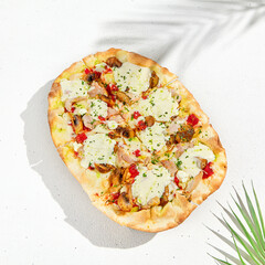 Roman pizza in summer style. Modern pinsa with mushrooms on white background. Roman pizza with mushrooms, ham, tomato sauce and mozzarella cheese