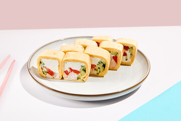 Mexican maki roll with chicken, paprika and cucumber inside, tortilla outside. Alternative sushi roll on coloured backdrop. Sushi menu concept. Maki sushi with chicken in minimal style