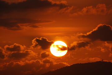 Fototapeta premium Beautiful Bright Sun rising emerging out of clouds