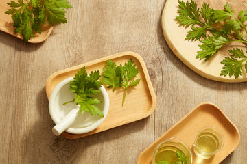 Top view of mugwort decorated with mortar and pestile wooden dish in wooden background for exfoliate advertising 