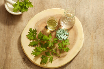 Top view of mugwort decorated with mortar and pestile wooden dish in wooden background for exfoliate advertising 
