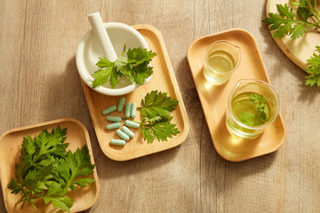Top view of mugwort decorated with mortar and pestile wooden dish in wooden background for exfoliate advertising 
