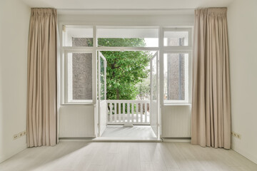 Access to a small balcony from a spacious room in a cozy house - obrazy, fototapety, plakaty