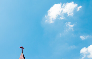 Christian cross on the rooftop against blue sky
