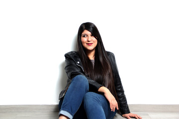 Happy and proud Latin young adult woman shows her long straight, black and shiny hair on a white...