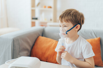 Sad little boy in mask from nebulizer close-up.