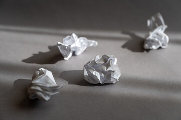 Crumpled pieces of white crumpled paper against a gray background.