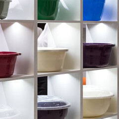 Many different plastic products, basins on the shelf. Industrial background. Household goods on display