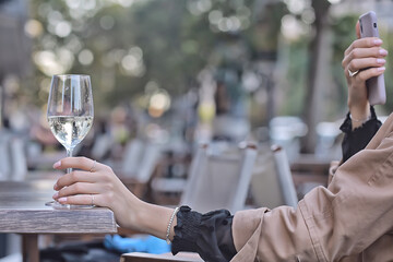 white wine glass in an outdoor cafe, spring view in a restaurant