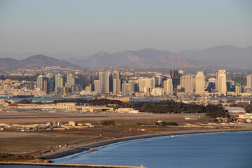 Fototapeta premium Looking over the skyline of Downtown San Diego, Naval Air Station North Island and the Peninsular Ranges in the distance from Point Loma
