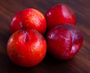 Fototapeta na wymiar Sweet organic red plums on kitchen table