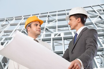 Multiethnic manual worker and engineer discussing on plan.  Architect supervisor meeting at construction site.