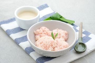 Kue Putu Mayang is traditional Indonesian snack made from rice flour strands curled up into a ball, served with coconut milk and palm sugar. Selected focus.
