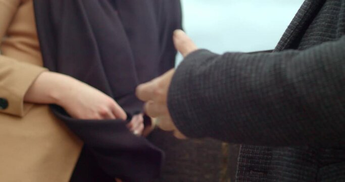 Male hands gesticulation during conversation with girl, holding notebook or diary, exterior closeup view